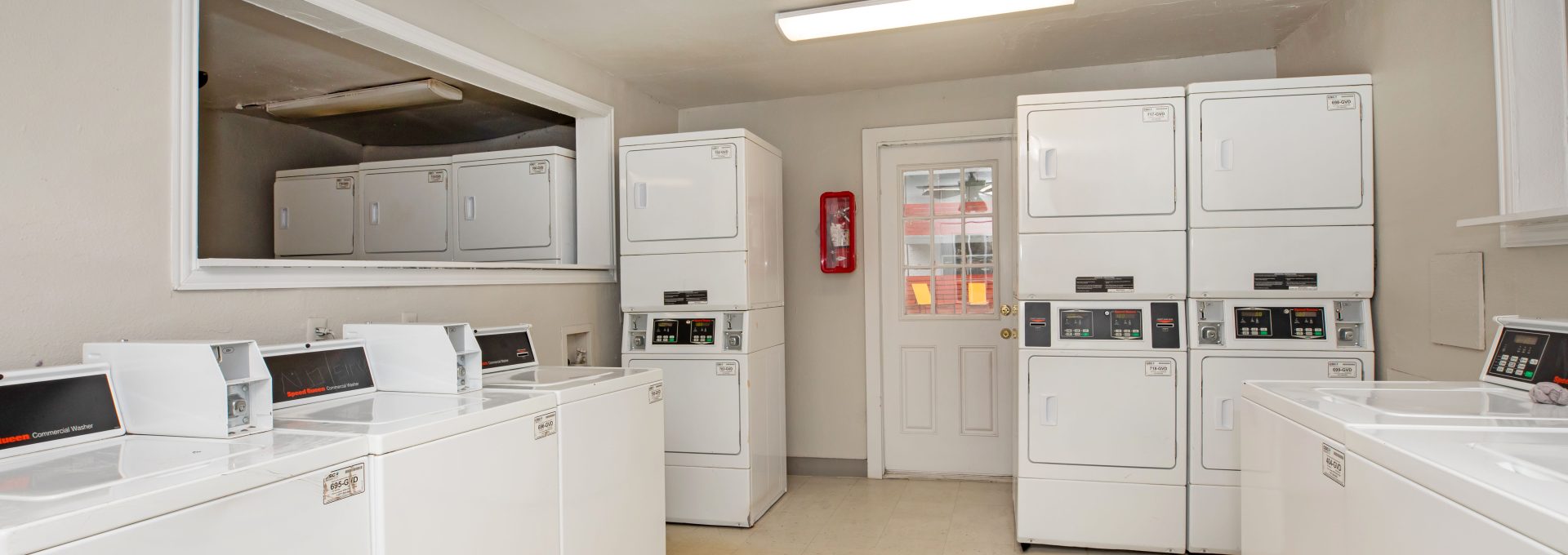 a laundry room with washers and dryers at The Cantera Apartment Homes