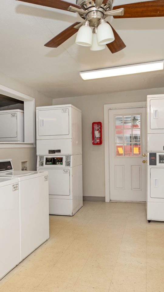 a laundry room with washers and dryers at The Cantera Apartment Homes