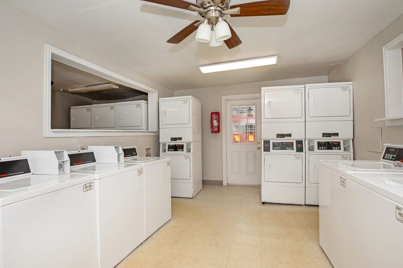 a laundry room with washers and dryers at The Cantera Apartment Homes