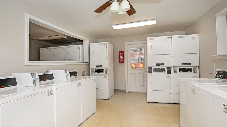 a laundry room with washers and dryers at The Cantera Apartment Homes