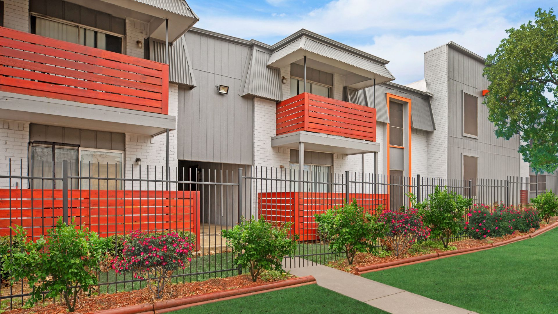 a rendering of a two story apartment complex with red railing at The Cantera Apartment Homes