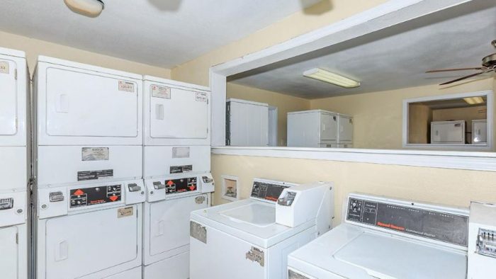 a laundry room with washers and dryers and a ceiling fan at The Cantera Apartment Homes